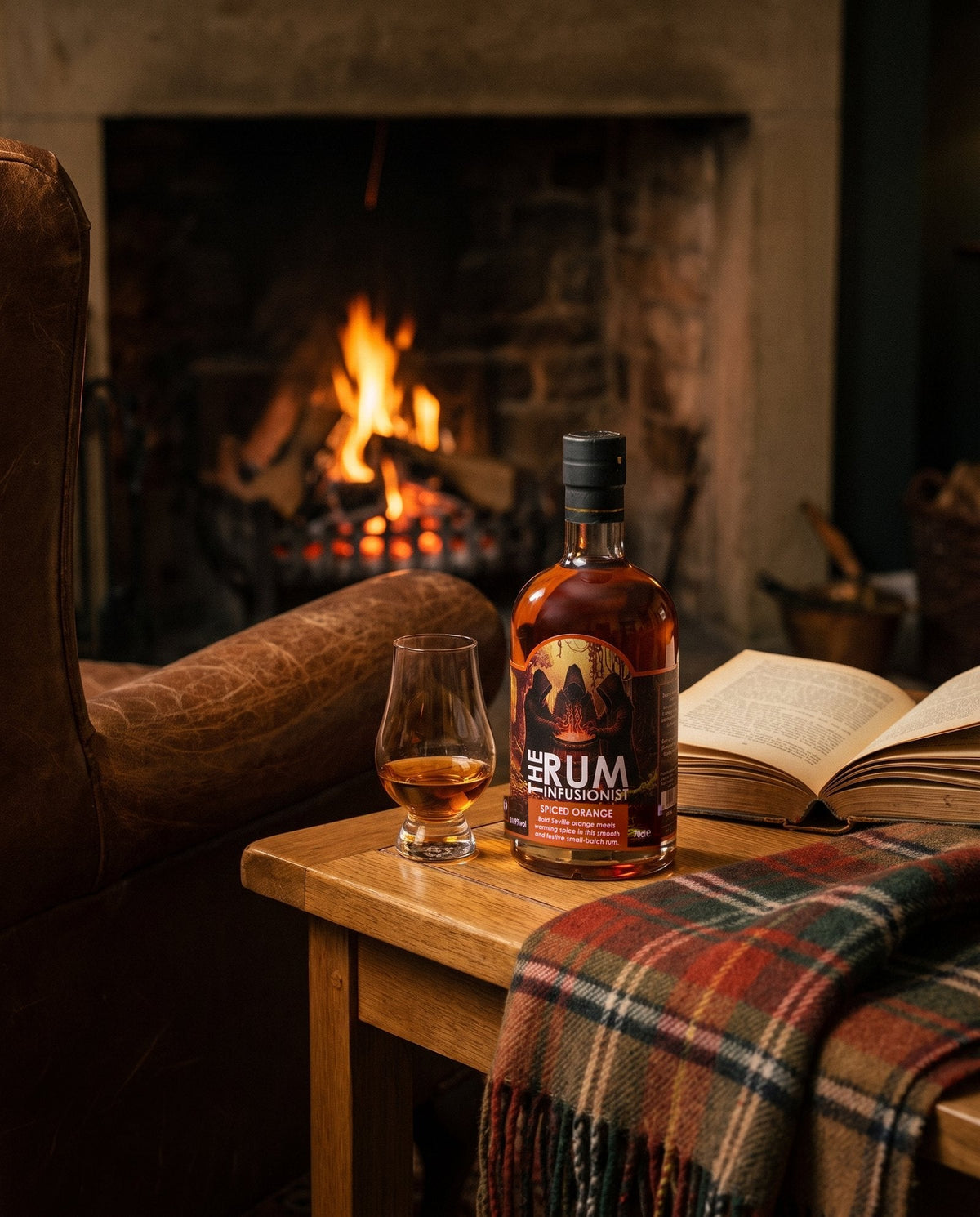 A glass of Spiced Orange served neat beside a leather armchair and log fire