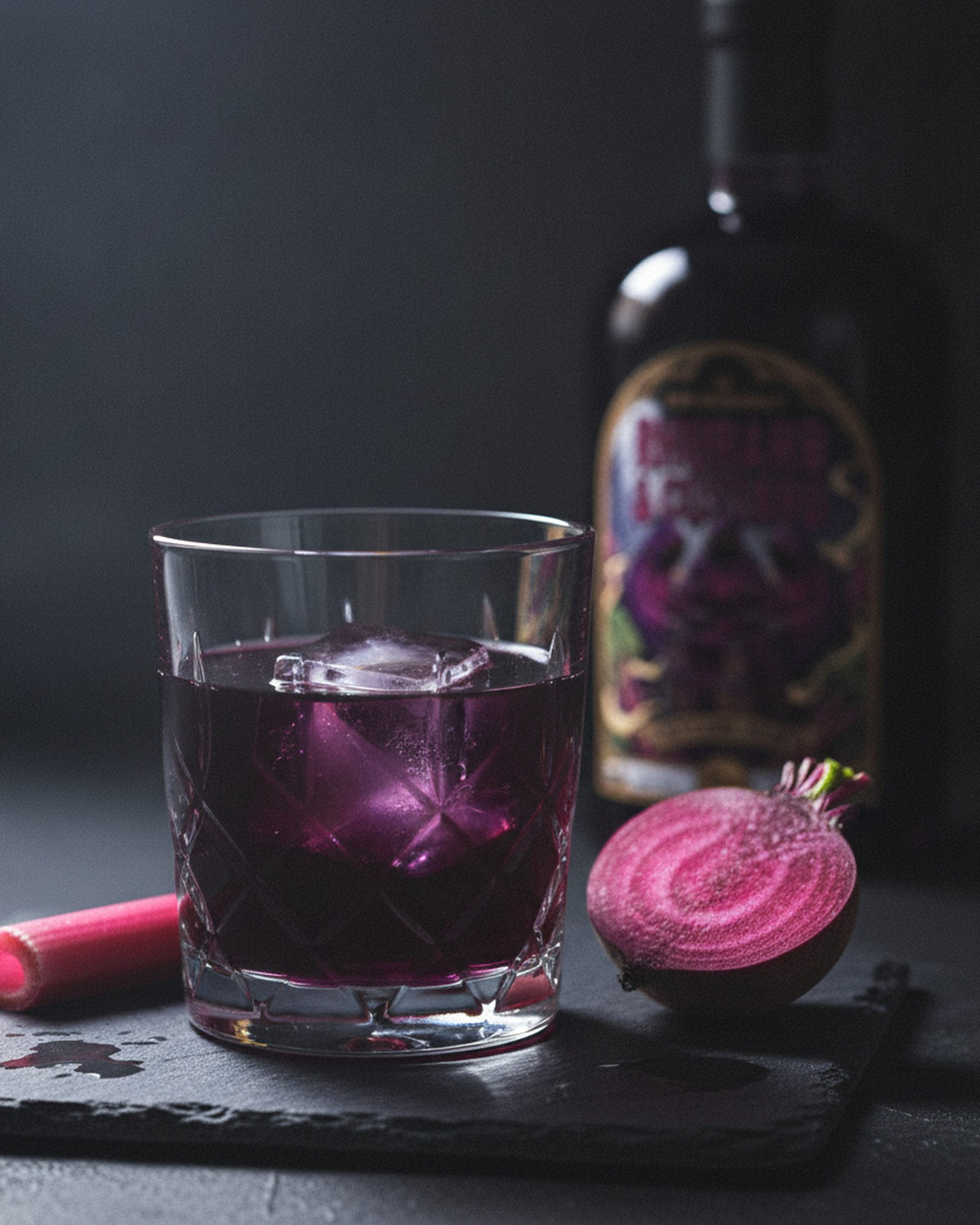 Witching Hour poured over ice beside the bottle with fresh forced rhubarb and beetroot